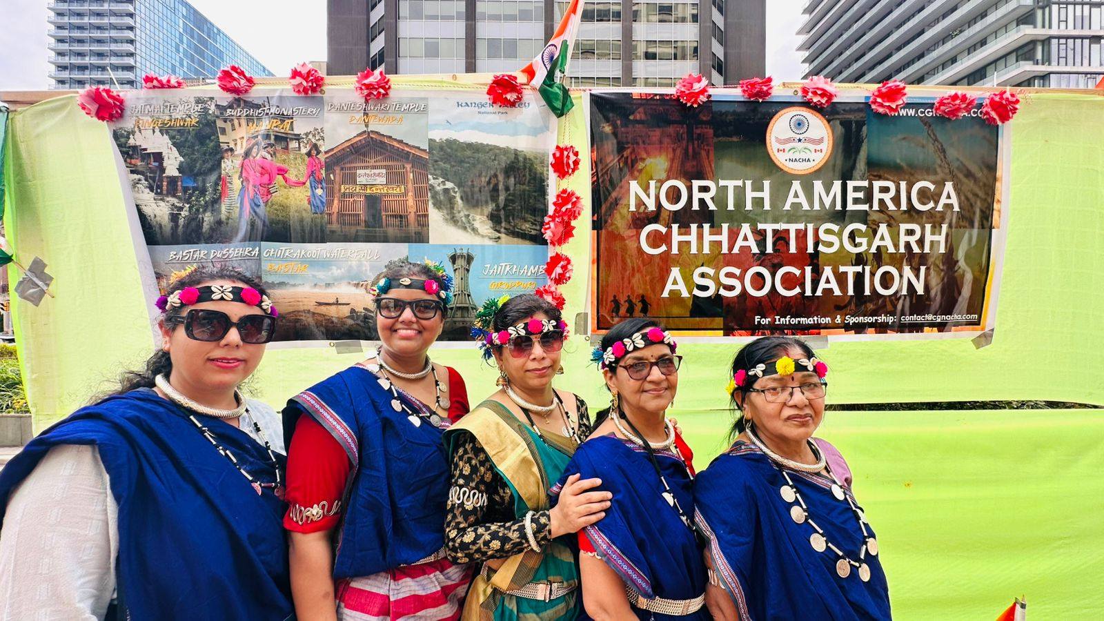 Chhattisgarhi women in blue sarees in front of the NACHA banner